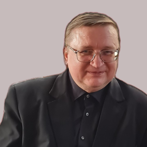 Portretas vyro su akiniais, dėvinčio juodą švarką ir marškinius.