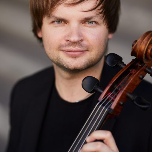 Vyras juodais drabužiais laiko violončelę.