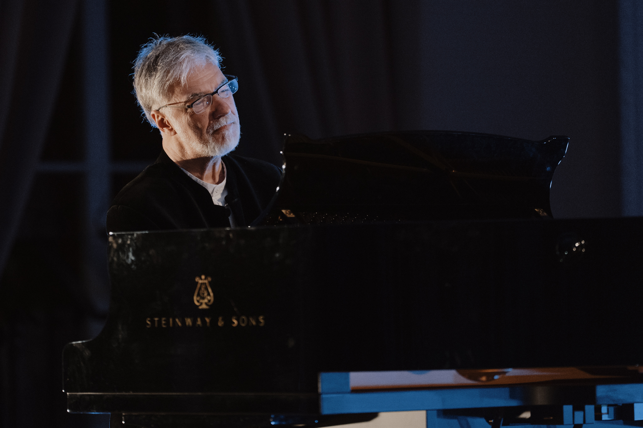 Vyresnis vyras su akiniais groja fortepijonu „Steinway & Sons“.